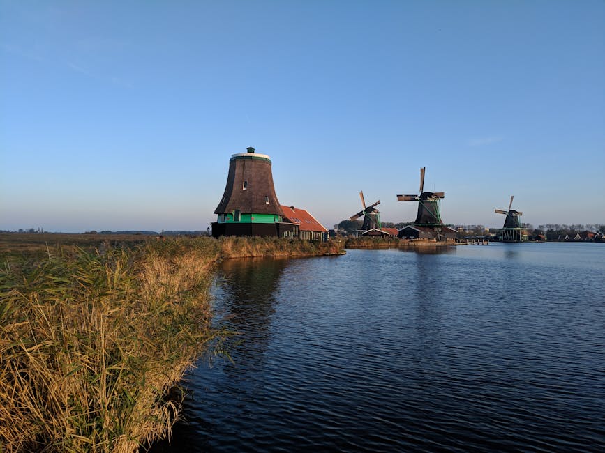 Historic windmills at Zaanse Schans in Zaandam, Netherlands overlooking the water.