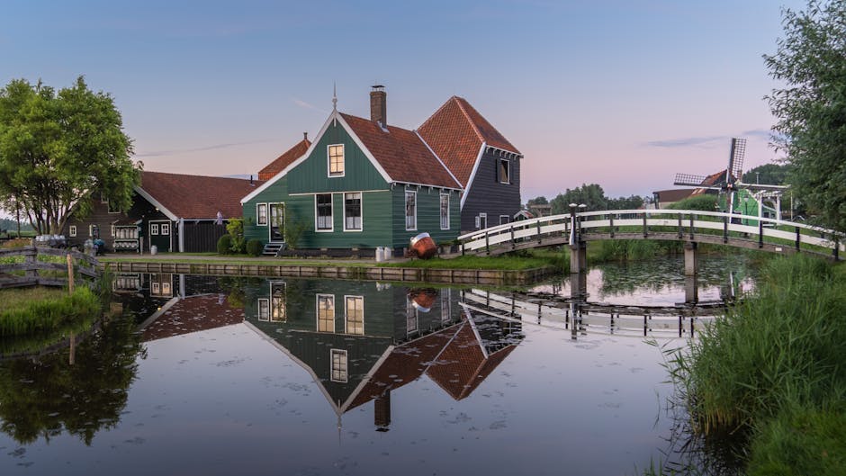 Scenic view of a traditional Dutch house with a reflection on a canal in Zaandam, Netherlands.